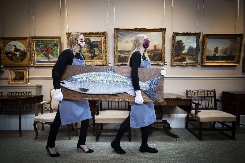 May Matthews (left) and Romy Clark from Bonhams Edinburgh carry a carved wooden model of an Atlantic Salmon by Rogers Brookes (estimate Â£1,500-2,000) during a photo call for the upcoming Home and Interiors sale, and Sporting and Wildlife sale, at Bonhams, Edinburgh, on September 16, 2020. (Photo by Jane Barlow/PA Images via Getty Images)
